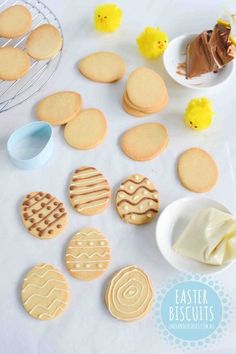 some cookies and icing on a white table with rubber ducky toys in the background