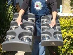 a person holding several trays of dog bowls