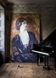 a painting on the wall next to a piano in a room with wood flooring