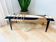 a surfboard shaped table sitting on top of a wooden floor next to a potted plant