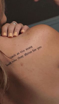 a woman with a tattoo on her back saying, look at the stars look how they shine for you