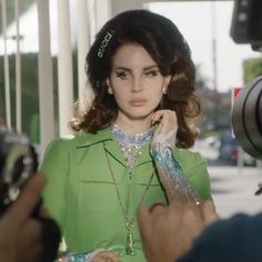 a woman in a green dress is being photographed