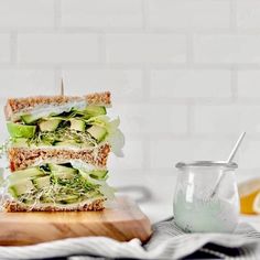 a sandwich cut in half sitting on top of a cutting board next to a jar