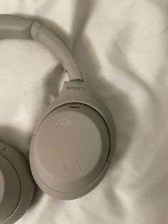 a pair of headphones laying on top of a white bed sheet with the word sony written on it