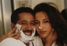 a man and woman with shaving cream on their faces are posing for a photo