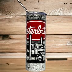 a coca - cola can with a straw sticking out of it's side on a wooden table