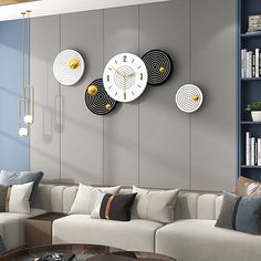 a living room filled with furniture and large clocks on the wall above it's head