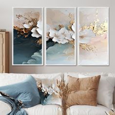 three paintings are hanging on the wall above a couch in a room with white furniture