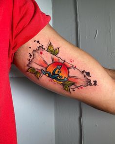 a man's arm with a tattoo on it that has an orange and blue flower