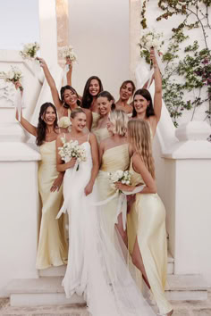 the bridesmaids are all dressed in yellow dresses and holding their bouquets up