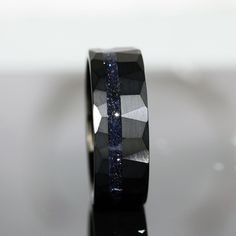 a black diamond ring sitting on top of a table