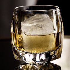 a glass filled with ice sitting on top of a table