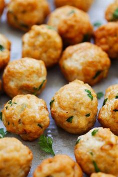 small appetizers are arranged on a sheet of wax paper with lemon wedges