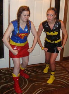 two women dressed in costumes standing next to each other on a carpeted floor with a door behind them