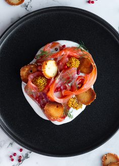 a black plate topped with food on top of a table