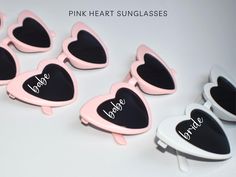 pink heart sunglasses with the word bride written on them in black and white letters, sitting next to each other