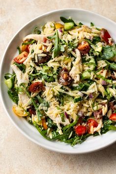 a white bowl filled with pasta salad on top of a table