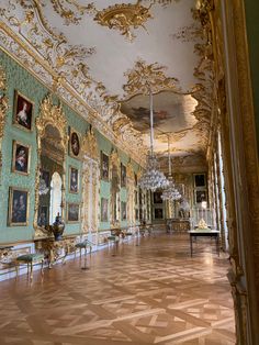 an ornately decorated room with chandeliers and paintings on the walls in gold