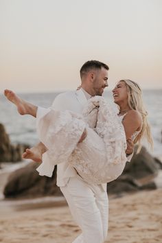 a man carrying a woman on his back at the beach