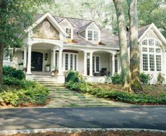 a white house surrounded by trees and bushes