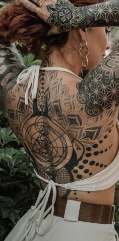 a woman with tattoos on her back and arms