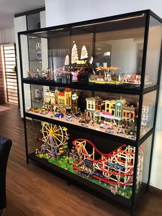 a display case filled with lots of toy cars and buildings on top of wooden floors