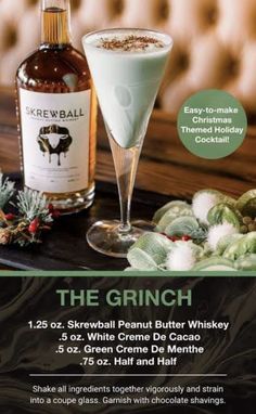 the grinch cocktail is served in a glass next to a bottle of booze