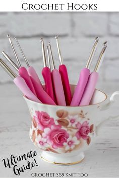 the ultimate crochet hooks are in a cup with pink flowers on it