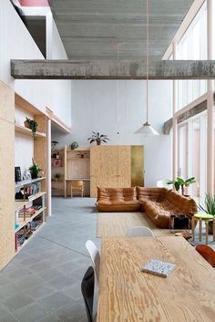 an open living room and dining area with wooden furniture in the center, along with bookshelves