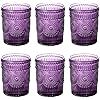 twelve purple glass cups with designs on them