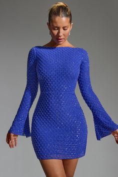 a woman wearing a blue dress with bell sleeves