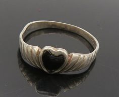 925 Sterling Silver - Vintage Black Onyx Love Heart Band Ring Sz 7 - RG16517  925 Sterling Silver - Vintage Black Onyx Love Heart Band Ring Sz 7 - RG16517  Jewelry Type:         Ring  Metal Type:            925 Silver  Metal Size:             7 Finger  Stone Type:            Onyx   Condition:              N/A  Jewelry Weight:     1.4 Grams  PLEASE NOTE: THIS ITEM IS PRE-OWNED. ALTHOUGH MOST ITEMS ARE IN VERY GOOD CONDITION, SOME MAY NEED CLEANING AND/OR MINOR REPAIRS. WE MAKE A VERY STRONG EFFORT TO UPLOAD CLEAR PICTURES. PLEASE INSPECT ALL PICTURES AND ASK ALL QUESTIONS YOU MAY HAVE PRIOR TO MAKING A PURCHASE. NOT ALL STONES ARE GENUINE, SOME ARE ENHANCED OR CREATED. Heart Band, Antique Rings, Black Onyx, Band Ring, Beautiful Necklaces, Vintage Black, Band Rings, Metallic Silver, Onyx