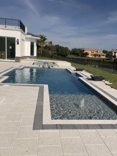 an empty swimming pool in front of a house