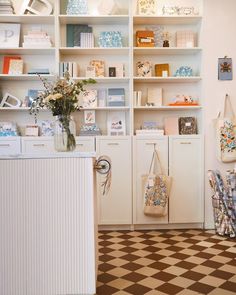 a room with many shelves and vases filled with flowers