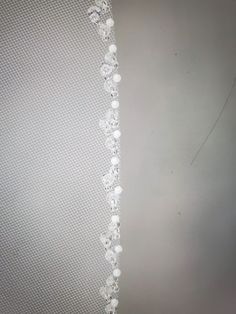 the beaded edge of a wedding dress with pearls and crystals hanging from it's side