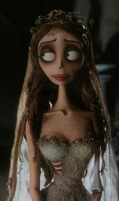 the corpse bride doll is dressed in white and has long brown hair, with eyes wide open