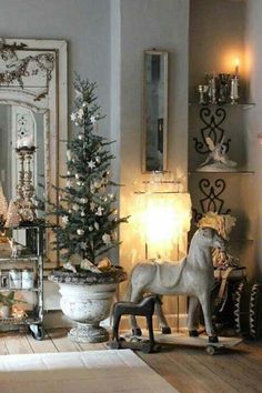 a white horse statue sitting next to a christmas tree in front of a mirror on a wall