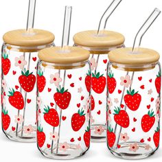 four strawberries and hearts are painted on glass jars with bamboo lids, one is holding stainless steel straws