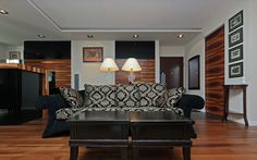 a black and white couch sitting on top of a hard wood floored living room