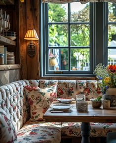 a table with flowers on it in front of a window