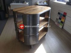 a kitchen island made out of metal and wood in the middle of a wooden floor