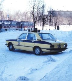 an old police car is parked in the snow