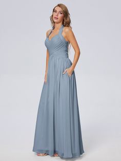 a woman in a long blue dress posing for the camera with her hands on her hips