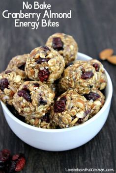 a white bowl filled with granola and raisins on top of a wooden table