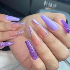 some purple and white nail designs on someone's hand with long nails in the middle