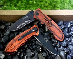 three knives sitting on top of rocks next to each other with the words groomsman written on them