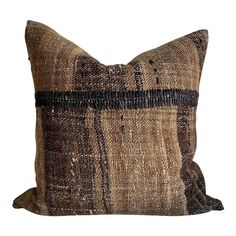 a brown and black pillow sitting on top of a white wall