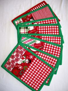 six christmas placemats with red and green checkered designs on them, all lined up in rows