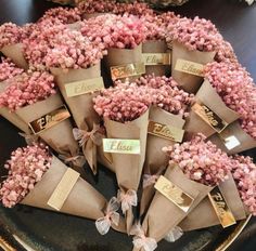 a bunch of pink flowers are wrapped in brown paper and tied with ribbon on a table