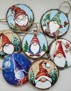 christmas ornaments with santa claus and gnomes painted on them are hanging from twine strings